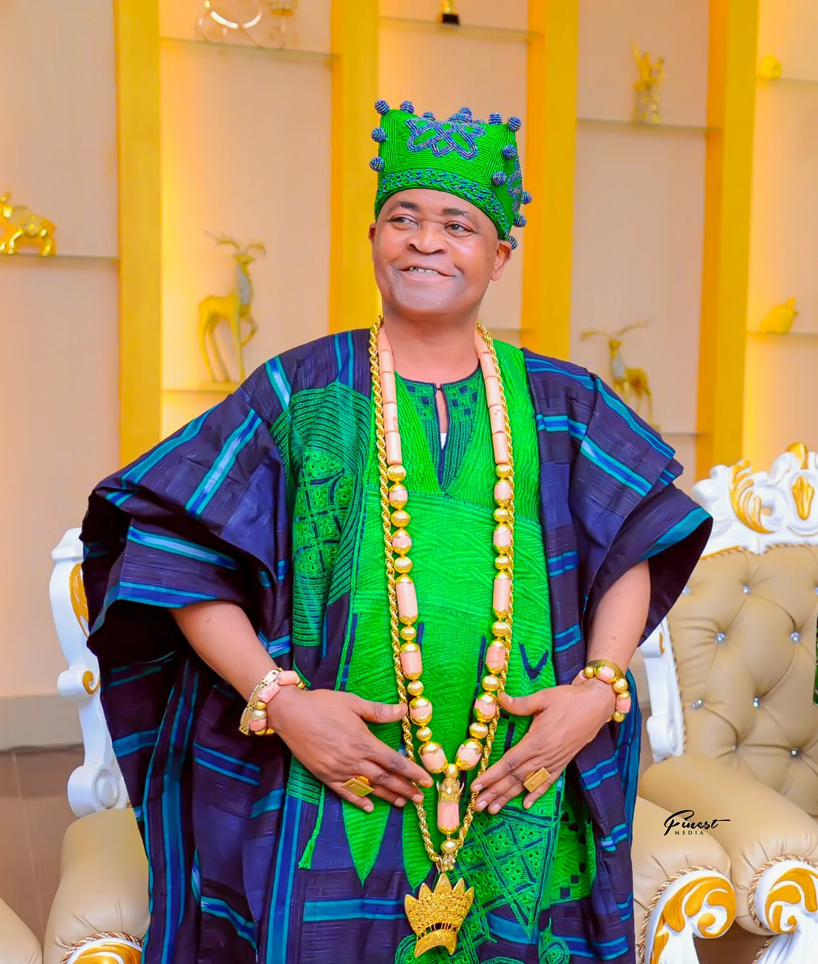 His Royal Majesty in green royal attire with crown